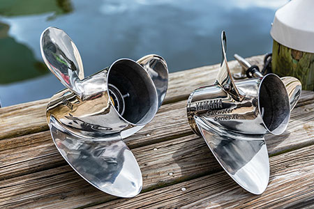 Two Yamaha propellers sitting on a dock.