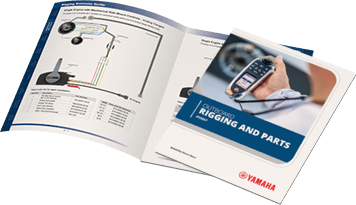 Yamaha Outboard Rigging and Parts catalog cover with a hand holding a digital gauge, next to an open spread showing wiring diagrams and parts list.