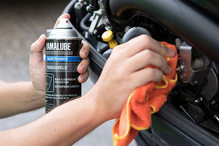 Someone using Yamalube Yamashield and a rag to prevent corrosion.