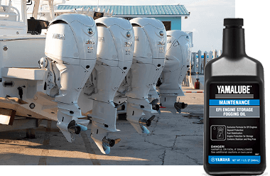 A boat with four white Yamaha Outboard engines. A bottle of Yamalube EFI Engine Storage Fogging Oil is in the foreground.